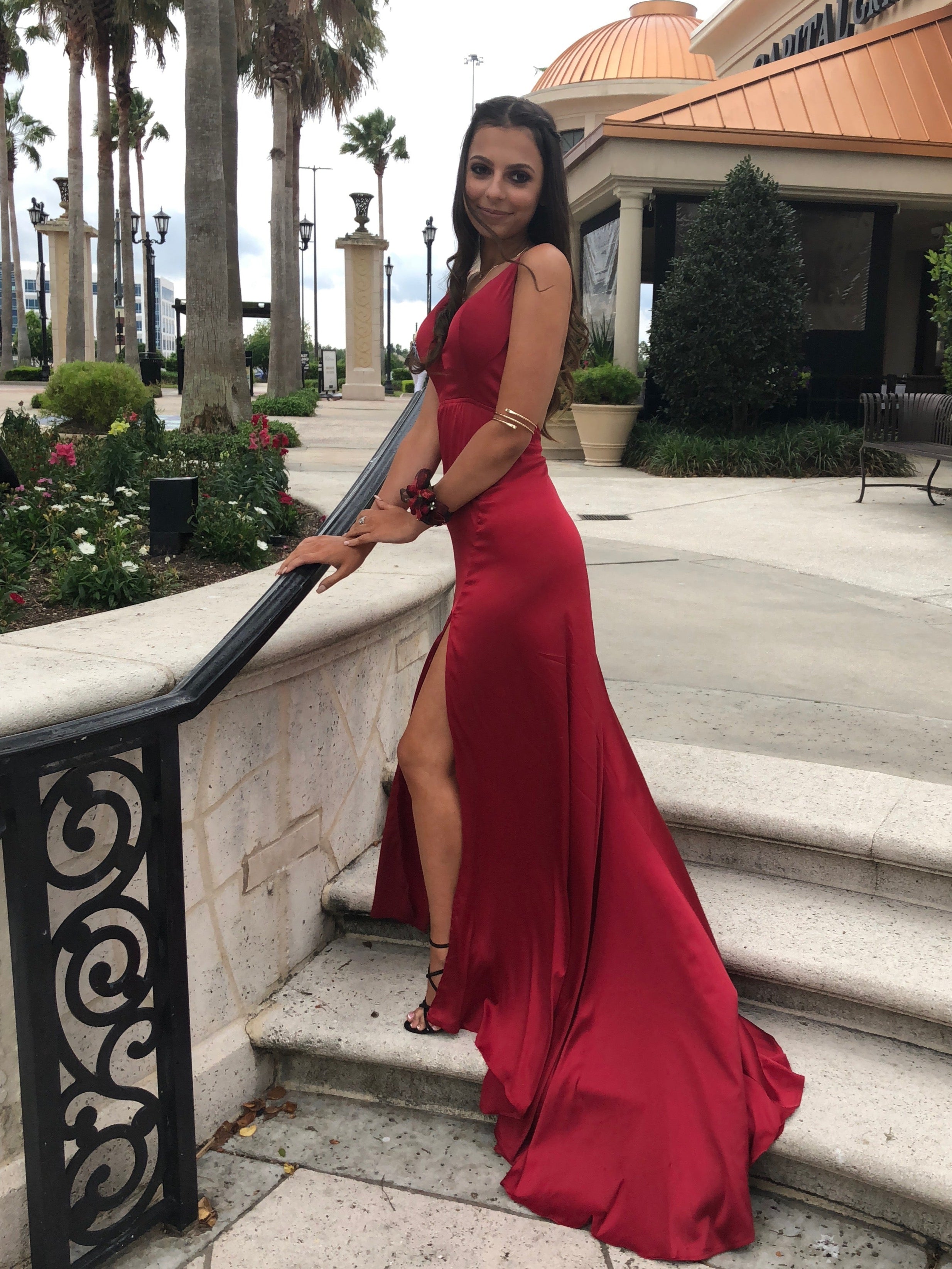 Woman in a red dress standing on steps outdoors